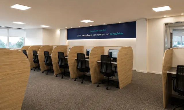 Ambiente de trabalho da CONECTTA com estações e painel da marca