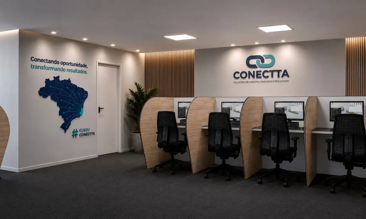 Estações de trabalho do coworking da CONECTTA, com o logo na parede